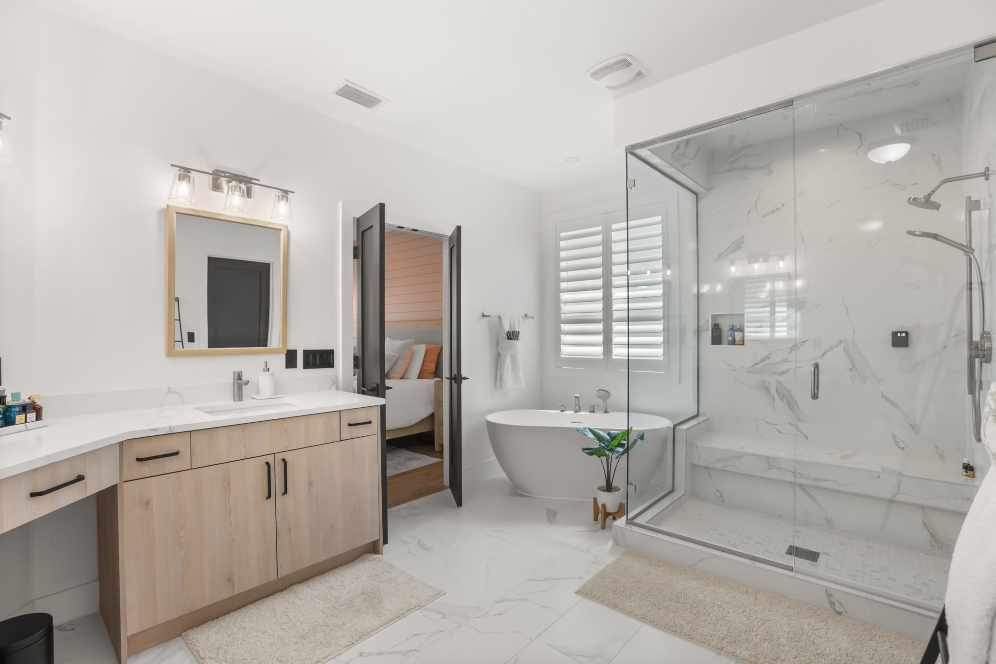 Primary bath with freestanding modern tub, custom glass shower and dual vanities
